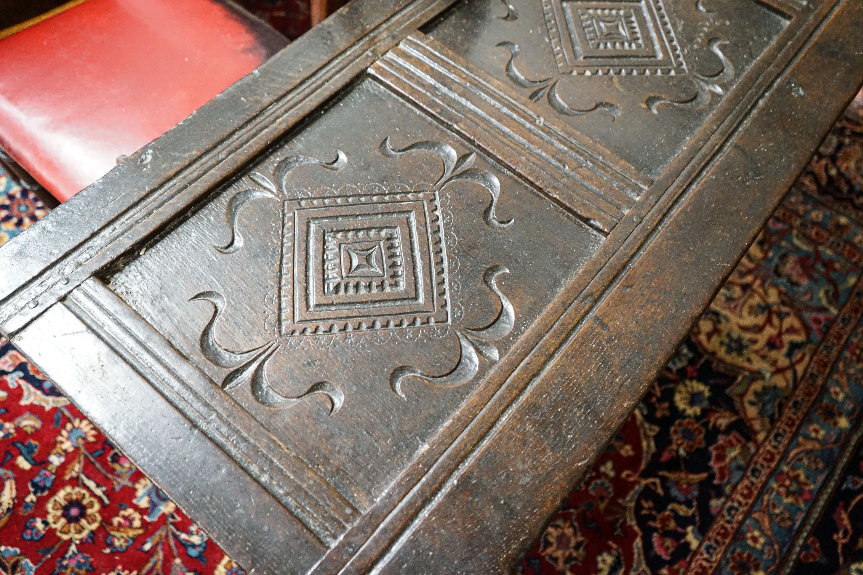 A late 17th/early 18th century carved and panelled oak coffer with hinged lid, width 136cm, depth 51cm, height 58cm